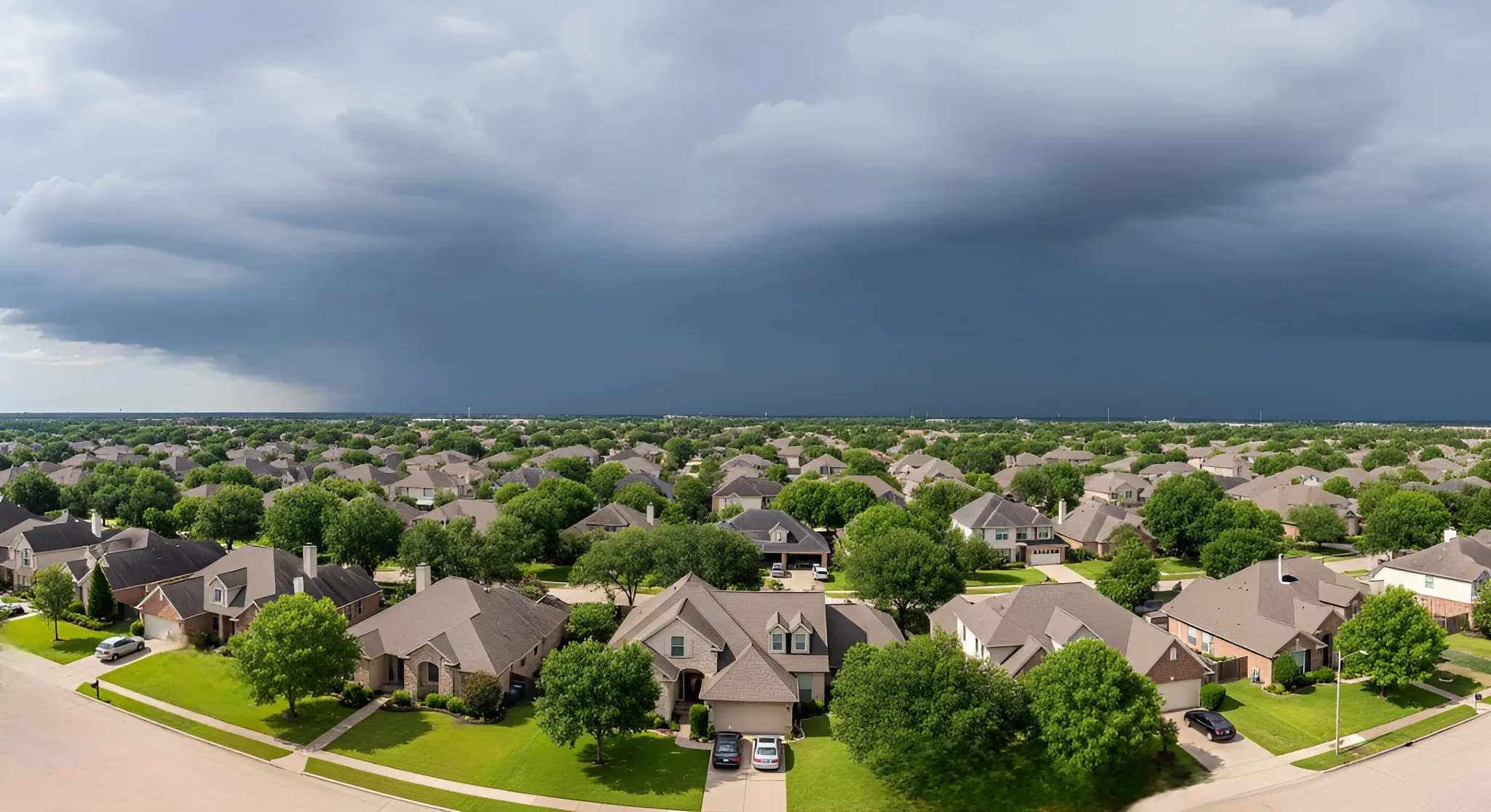 Houston neighborhood roofs under bright sun and stormy sky, showing climate challenges