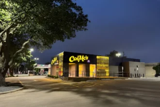 Nighttime view of CosMc’s restaurant in Dallas with bright yellow lights and signage, surrounded by an empty parking lot