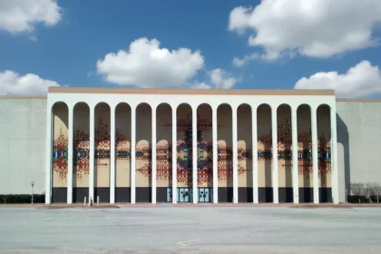 Exterior facade of the former Sanger-Harris department store at Valley View Center in Dallas, featuring tall white arches and a colorful geometric tile mosaic, photographed in 2012