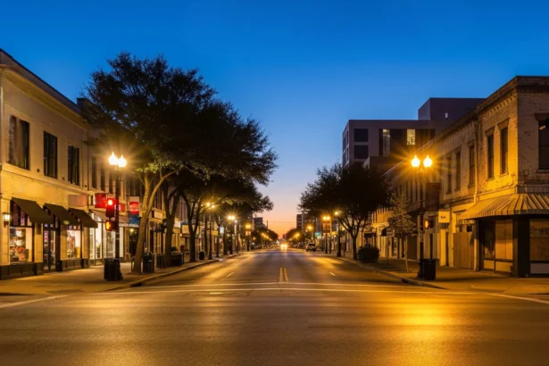 Dallas street intersection showing contrasting neighborhood lighting and upkeep at dusk