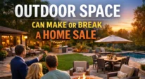 Real estate agent showing buyers a landscaped backyard with a fire pit, patio seating, and pool at sunset.