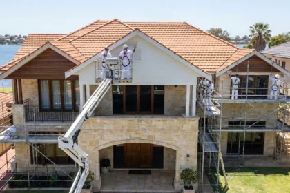 Professional painters working on a large Perth home with high walls and hard-to-reach areas