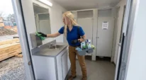 Technician servicing a restroom trailer at a construction site