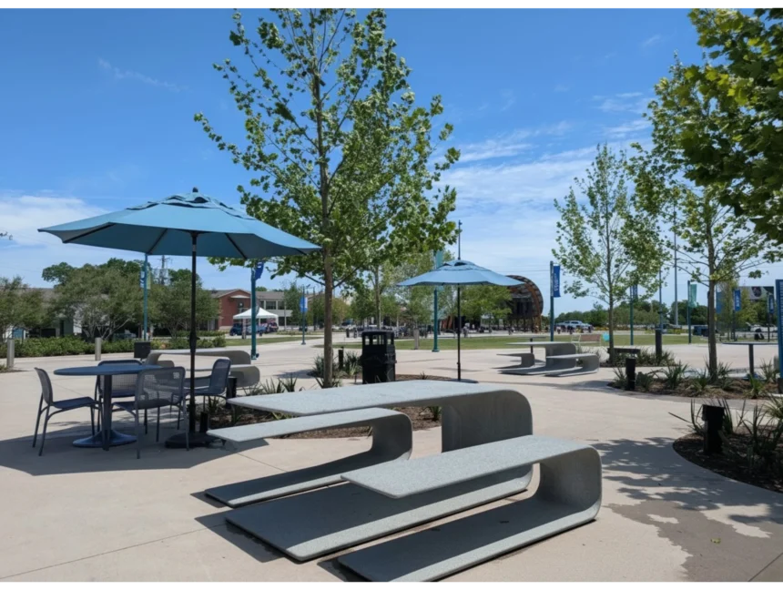 A sunny day shot of Halperin Park, featuring unique, curved concrete picnic benches